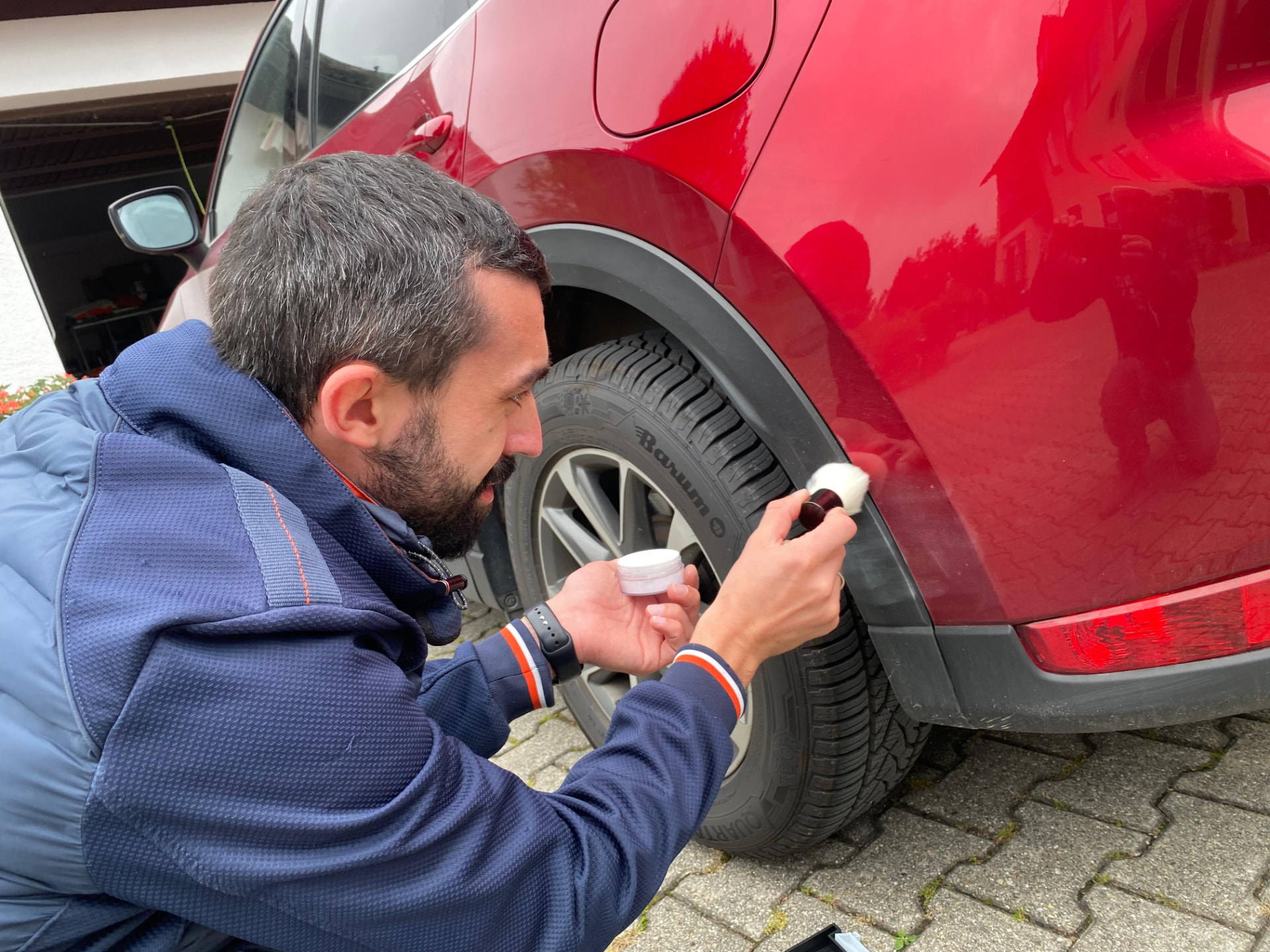 Kfz-Sachverständiger prüft einen Karosserieschaden am roten SUV